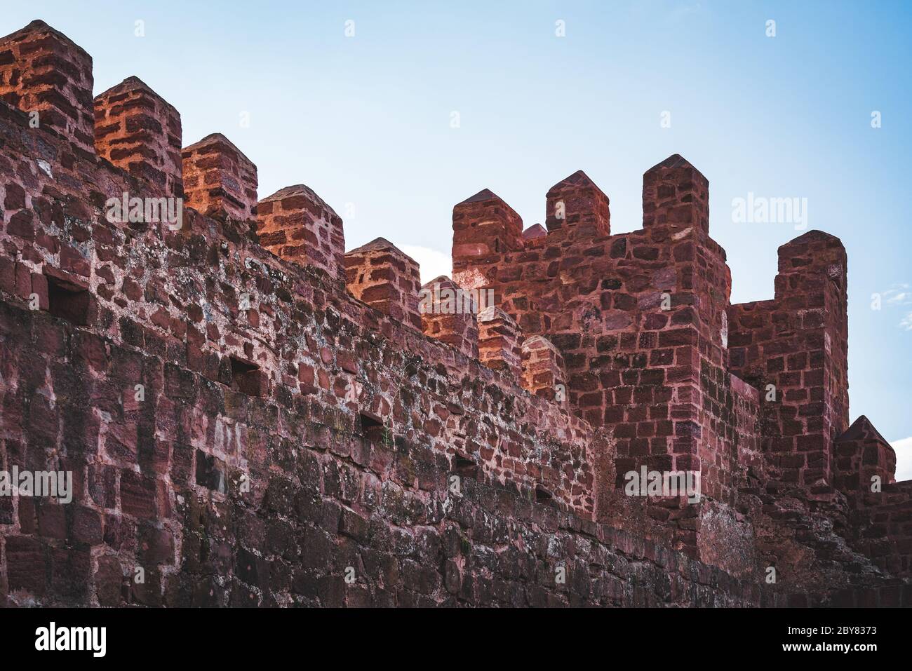 Facciata interna e torre di un castello medievale, fatto di massi rossi rodeno Foto Stock