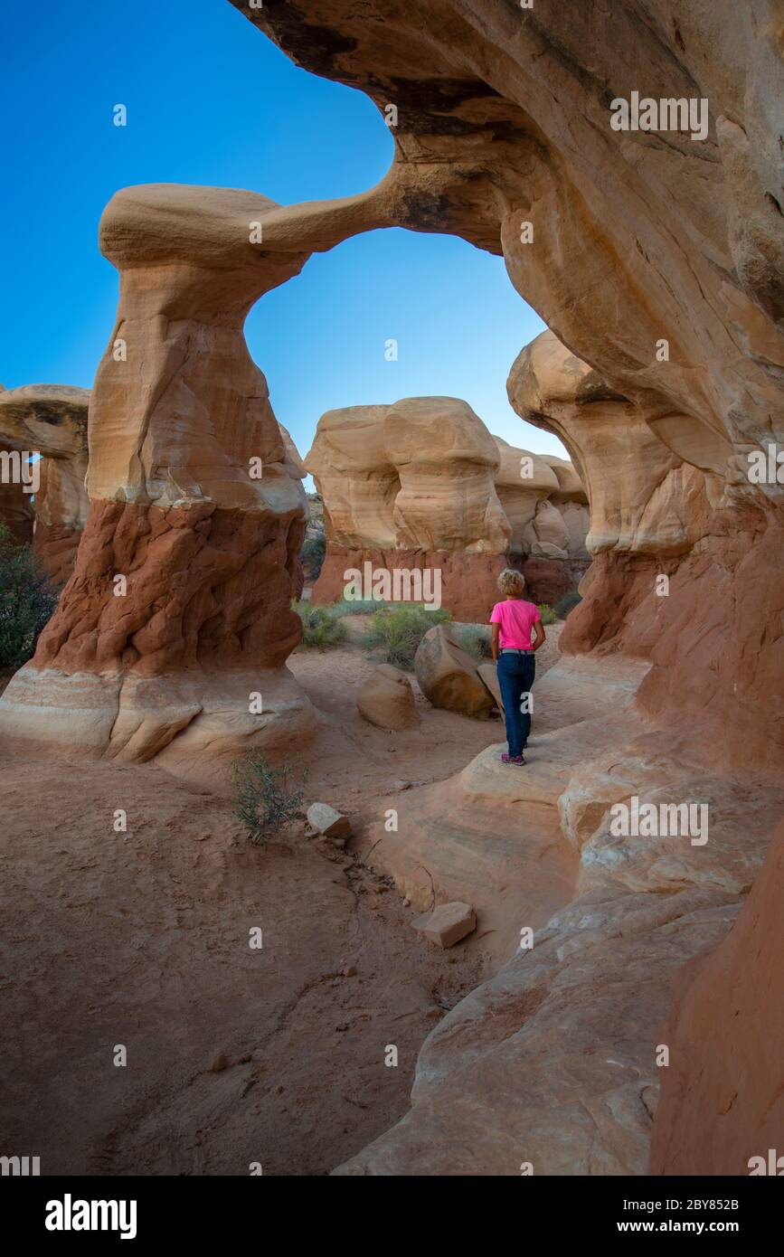 USA, Colorado Plateau, Utah, il Devil's Garden of the Grand Staircase-Escalante National Monument, donna che camminano al Metate Arch MR Foto Stock