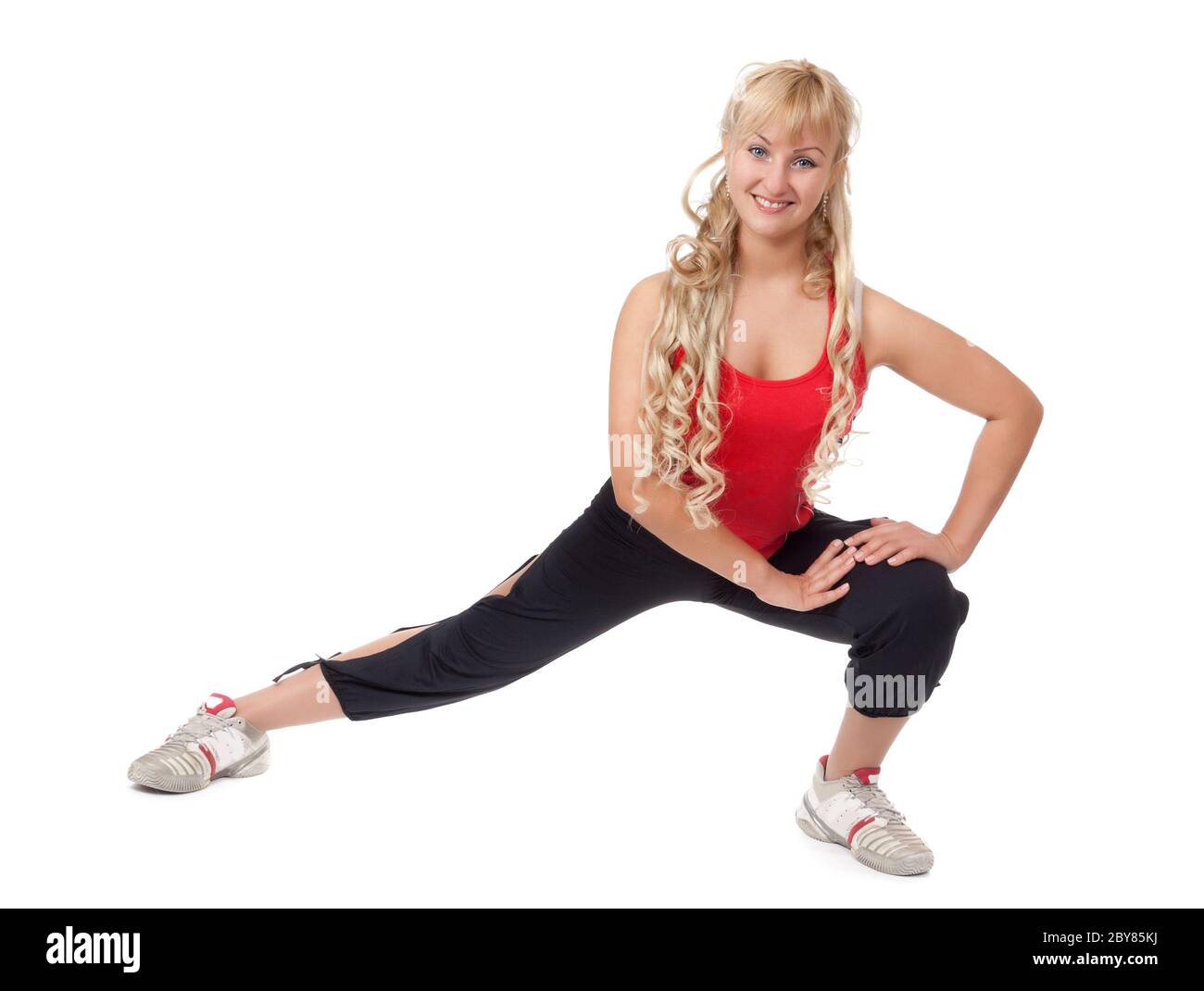 Bella giovane bionda è impegnata in forma fisica, dimostra la flessibilità del corpo isolato su sfondo bianco Foto Stock