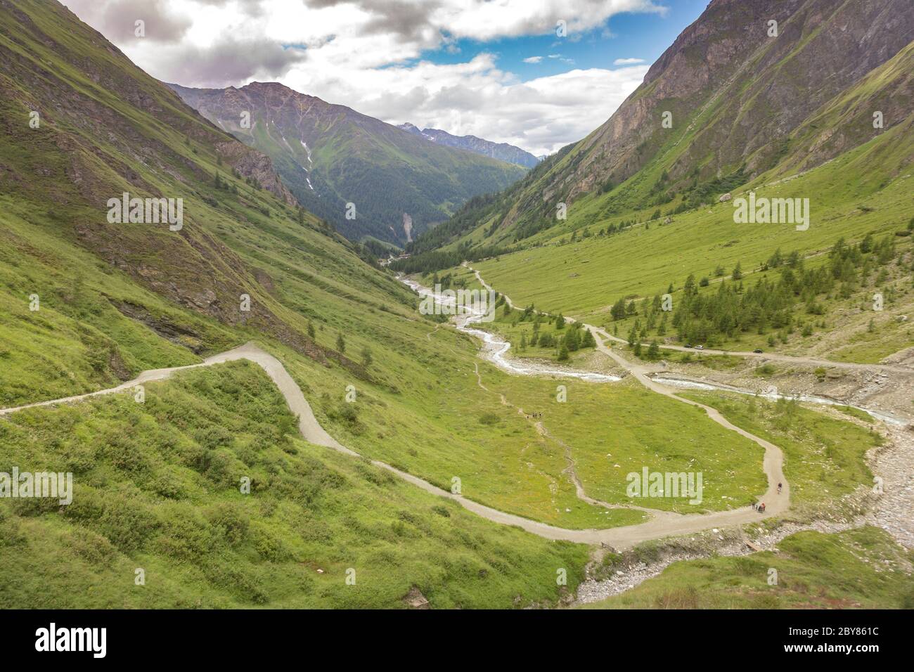 Fiume di montagna, percorso turistico e una valle verde tra le montagne delle Alpi austriache. Vista dalla strada per la cima rocciosa di Grossglockner, Kals am Gross Foto Stock