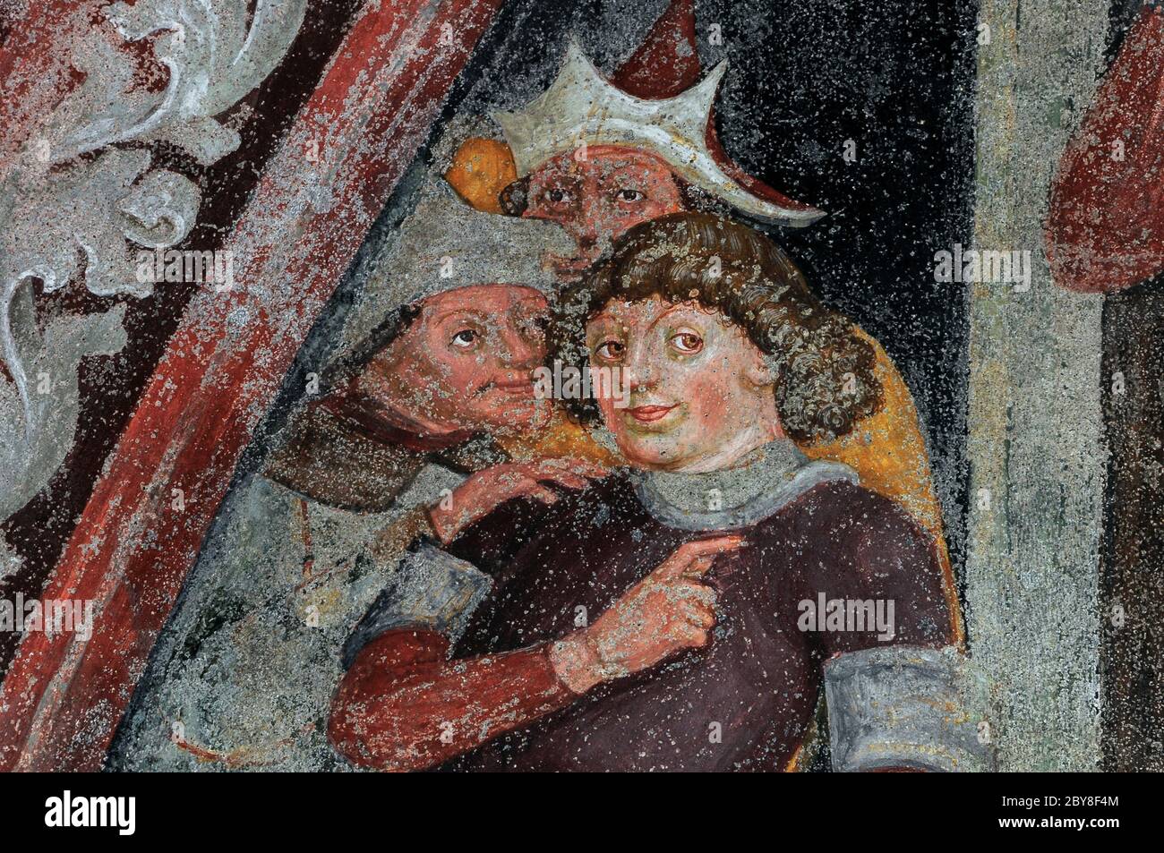 Sopracciglia alzate e dita mentre tre uomini medievali guardano e sussurrano. Dettaglio dall'affresco tardogotico nel chiostro medievale accanto al Duomo di Bressanone (Cattedrale di Santa Maria Assunta) a Bressanone-Bressanone, alto Adige, Italia. Foto Stock