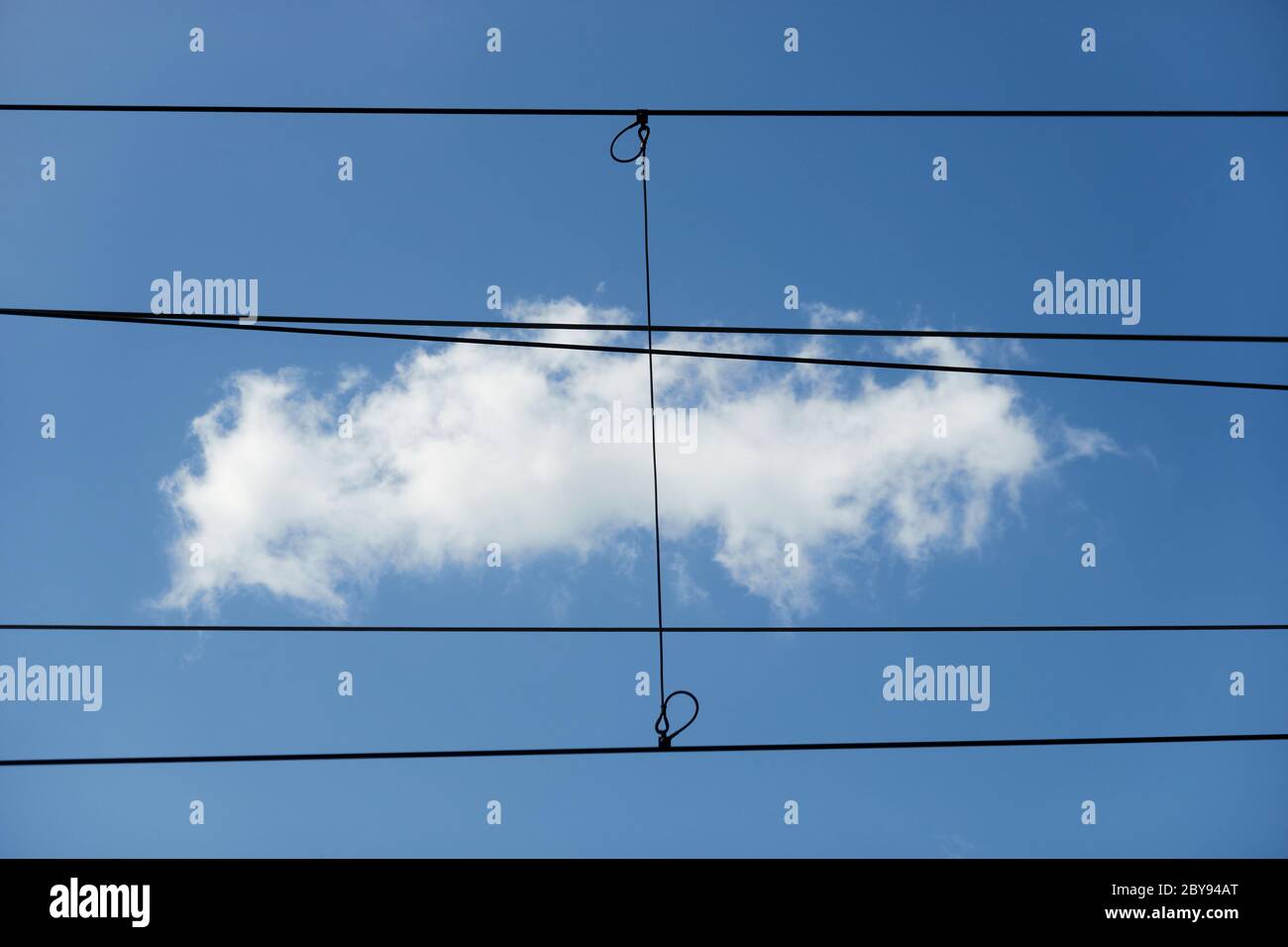 Immagine astratta, piccola nuvola bianca in cielo blu dietro le linee diritte e rigide dei cavi di alimentazione e di controllo Foto Stock