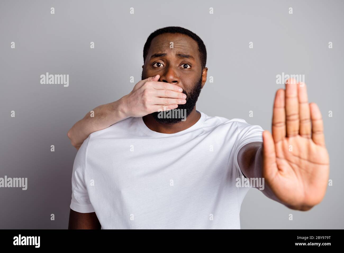 Foto di un ragazzo afro-americano disenfranchised società ingiustamente chiuso nero razza cittadino pregare fermare bullismo braccio bianco pelle vicino la sua bocca Foto Stock