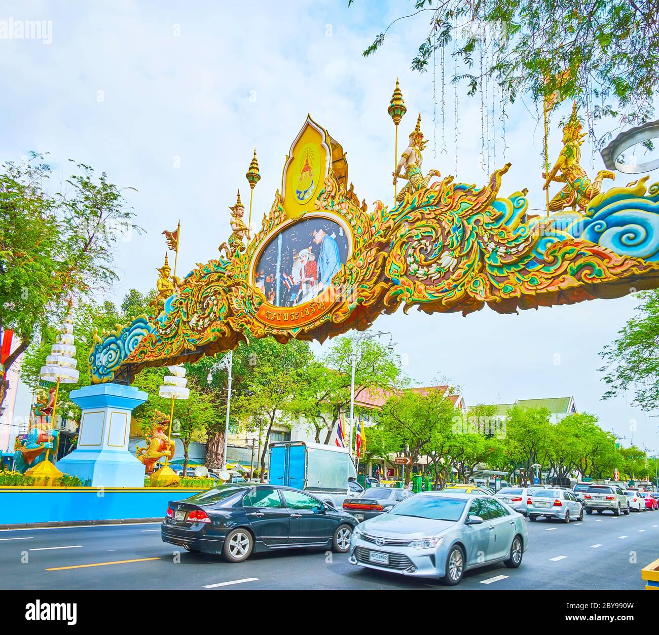 BANGKOK, THAILANDIA - 13 MAGGIO 2019: Il traffico intenso nel viale Ratchadamnoen, decorato con archi ornamentali e ghirlande a causa dell'incoronazione della RAM Foto Stock