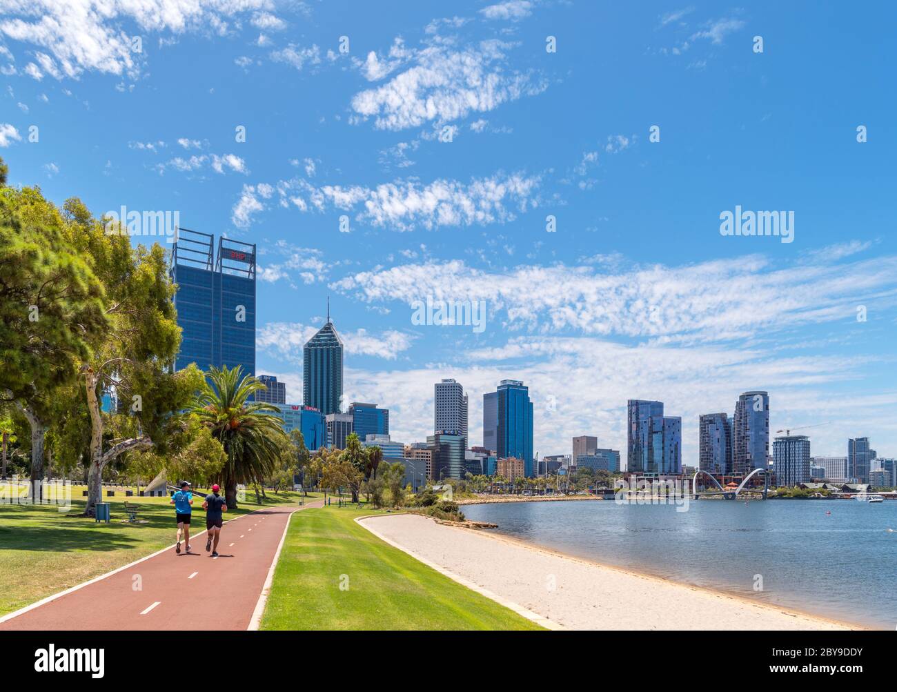 Runner sul lungofiume e pista ciclabile che guarda verso lo skyline del centro, Riverside Drive, David Carr Memorial Park, Perth, Australia Foto Stock