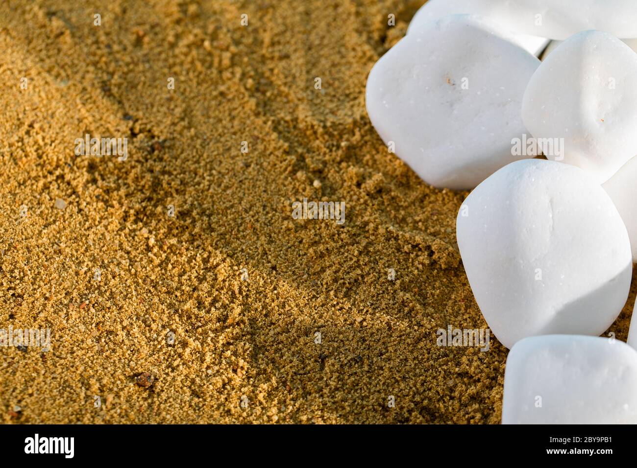 Rocce bianche rotonde giacciono sul cigolio appena fuori dalla riva. Giornata di vacanza calda e soleggiata. Foto Stock