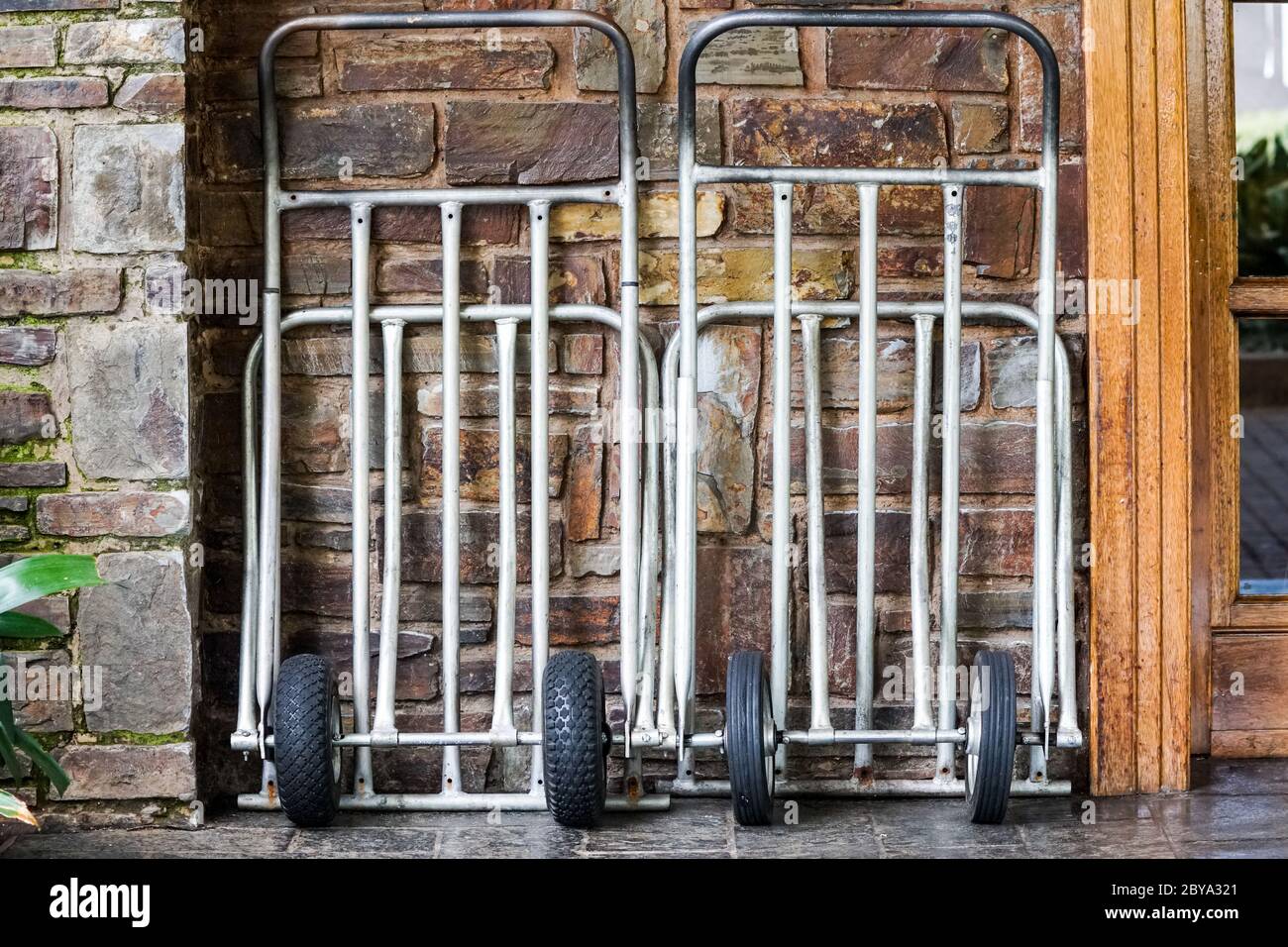 carrelli o carrelli per bagagli contro un muro di un hotel che sono vuoti concetto di vacanza, vacanza, viaggio, turismo Foto Stock