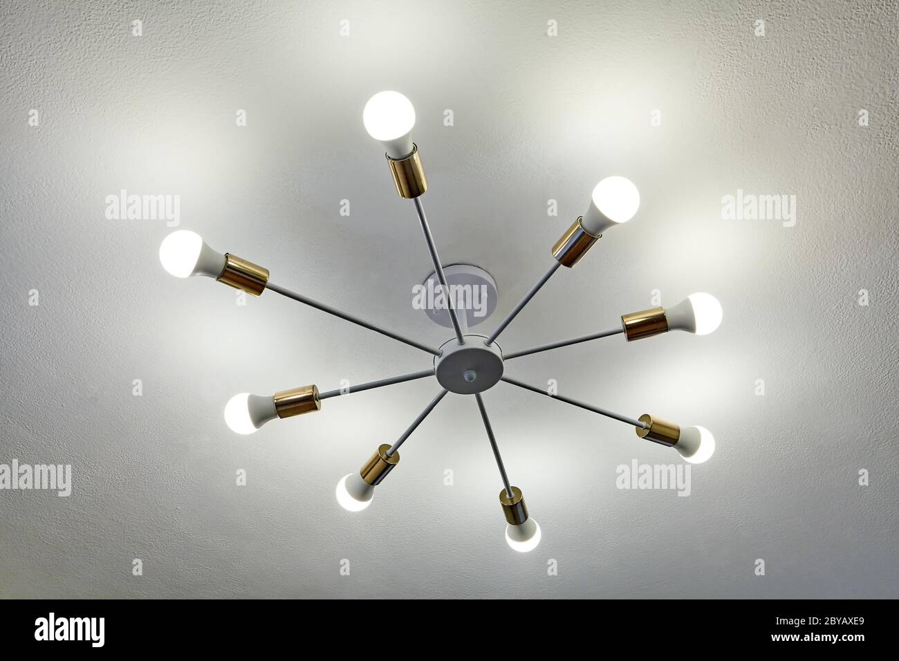 Lampadario a soffitto in alluminio con otto travi, alla fine dei quali sono di lampadine a LED. Illuminazione domestica economica. Foto Stock