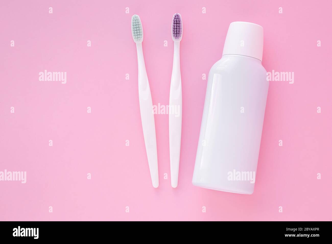 Spazzole dentali e boccaglio su sfondo rosa. Concetto di cura dei denti, igiene orale. Spazio di copia. Posizione vuota per il testo Foto Stock