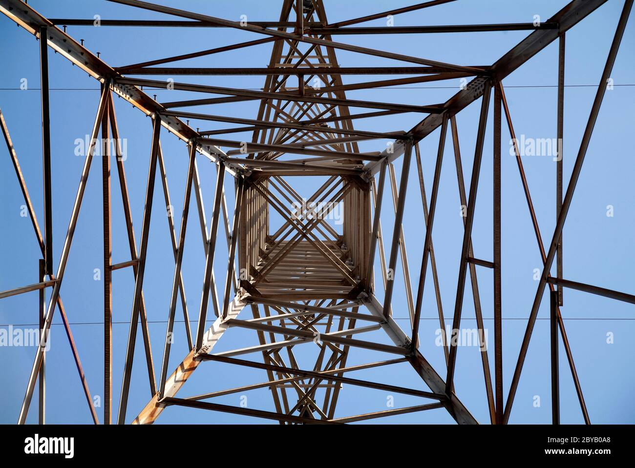 GRIDLOCK: Uno sguardo verticale a 90 gradi alle torri elettriche ad alta tensione dei giorni nostri. Foto Stock