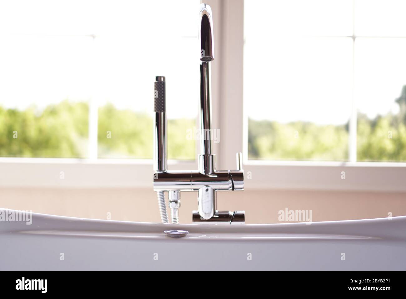 Bagno moderno con interni luminosi e grande finestra e luce solare Foto Stock