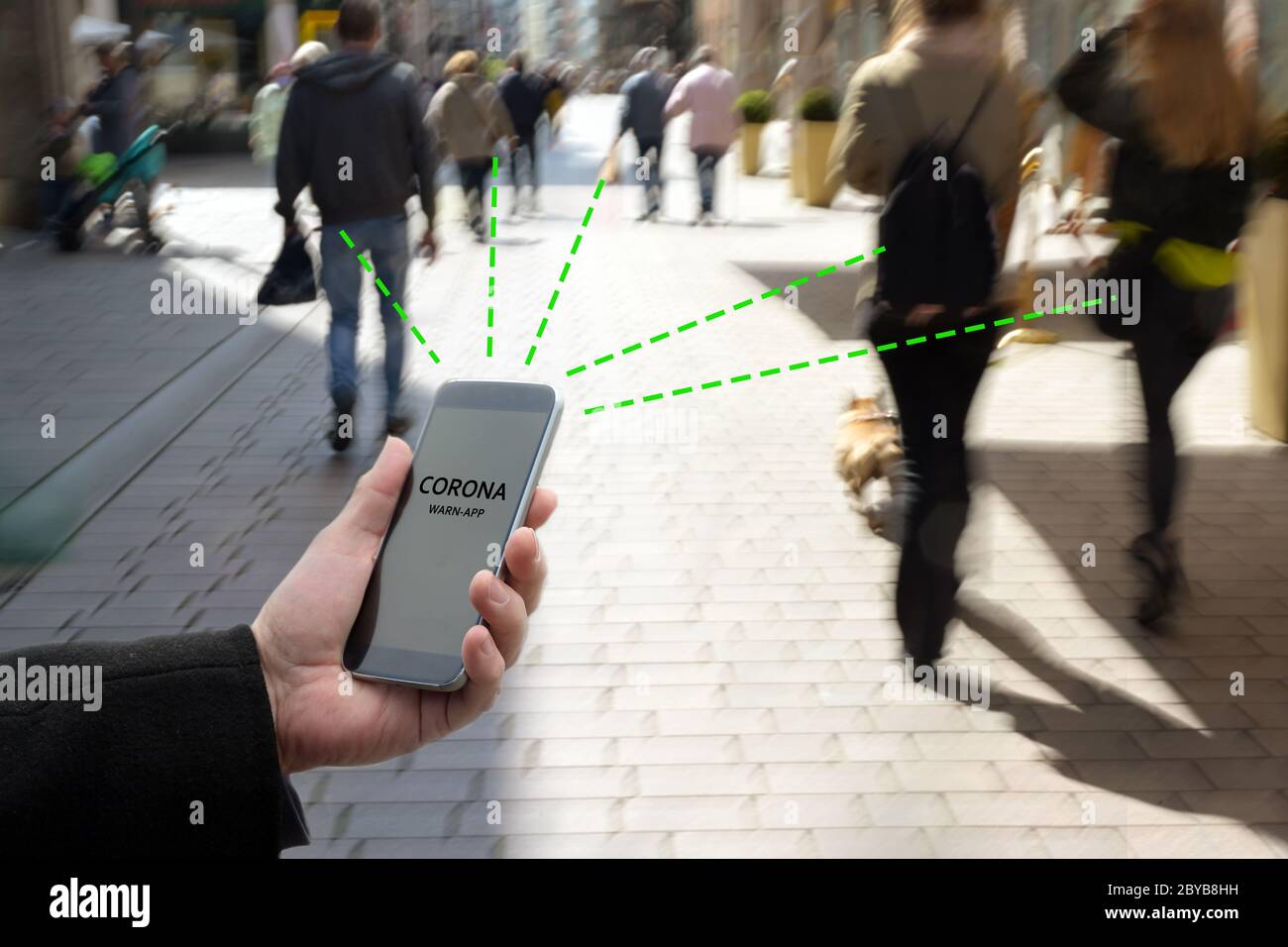 Smartphone con l'applicazione Corona WARN, l'applicazione di tracciamento dei contatti o di tracciamento della pandemia di Covid 19 collega altri telefoni da persone in movimento Foto Stock