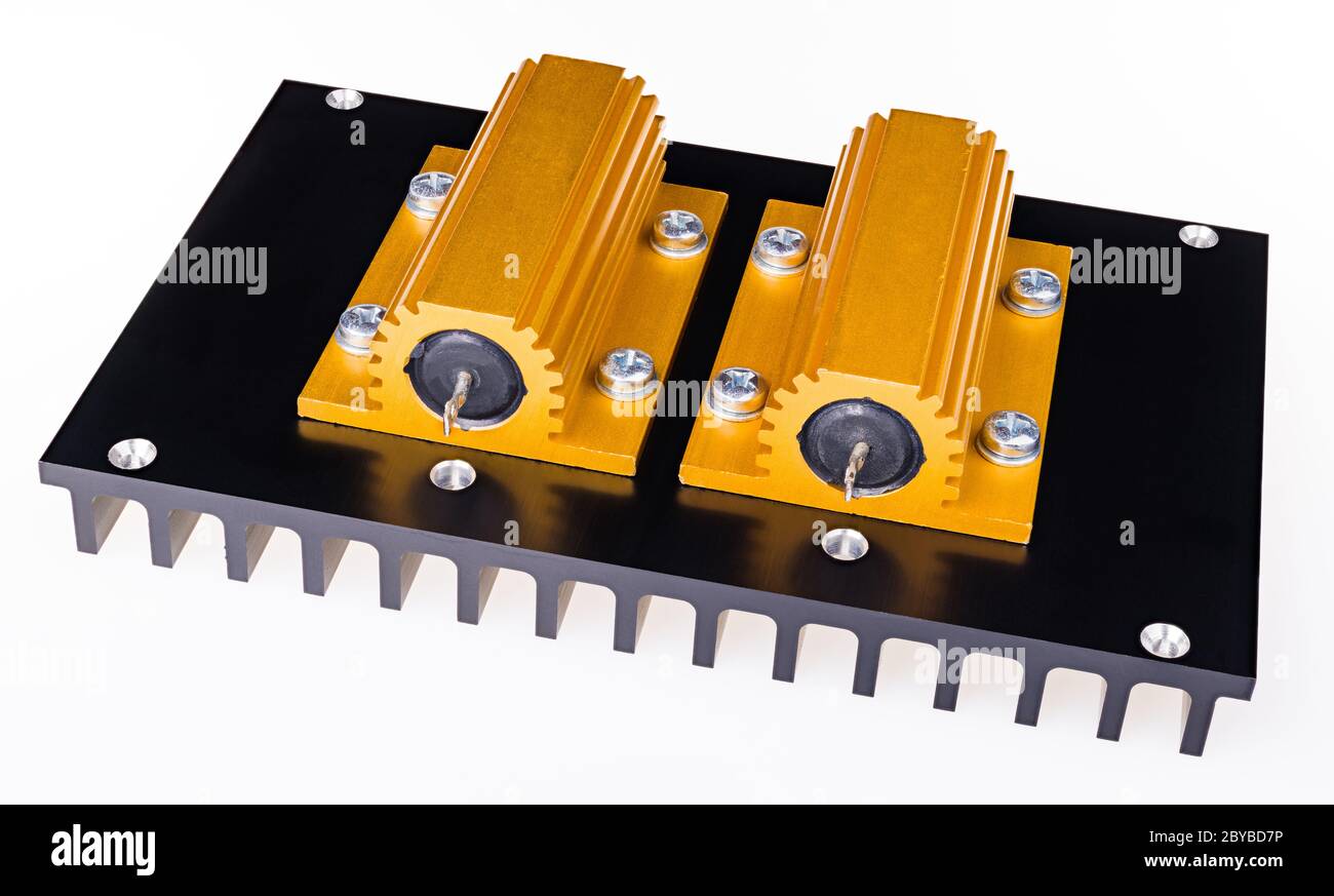 Due resistenze di potenza gialle imbullonate su un dissipatore di calore in alluminio anodizzato nero. Primo piano dei componenti passiveelettrici racchiusi in una custodia esterna dorata sul refrigeratore. Foto Stock