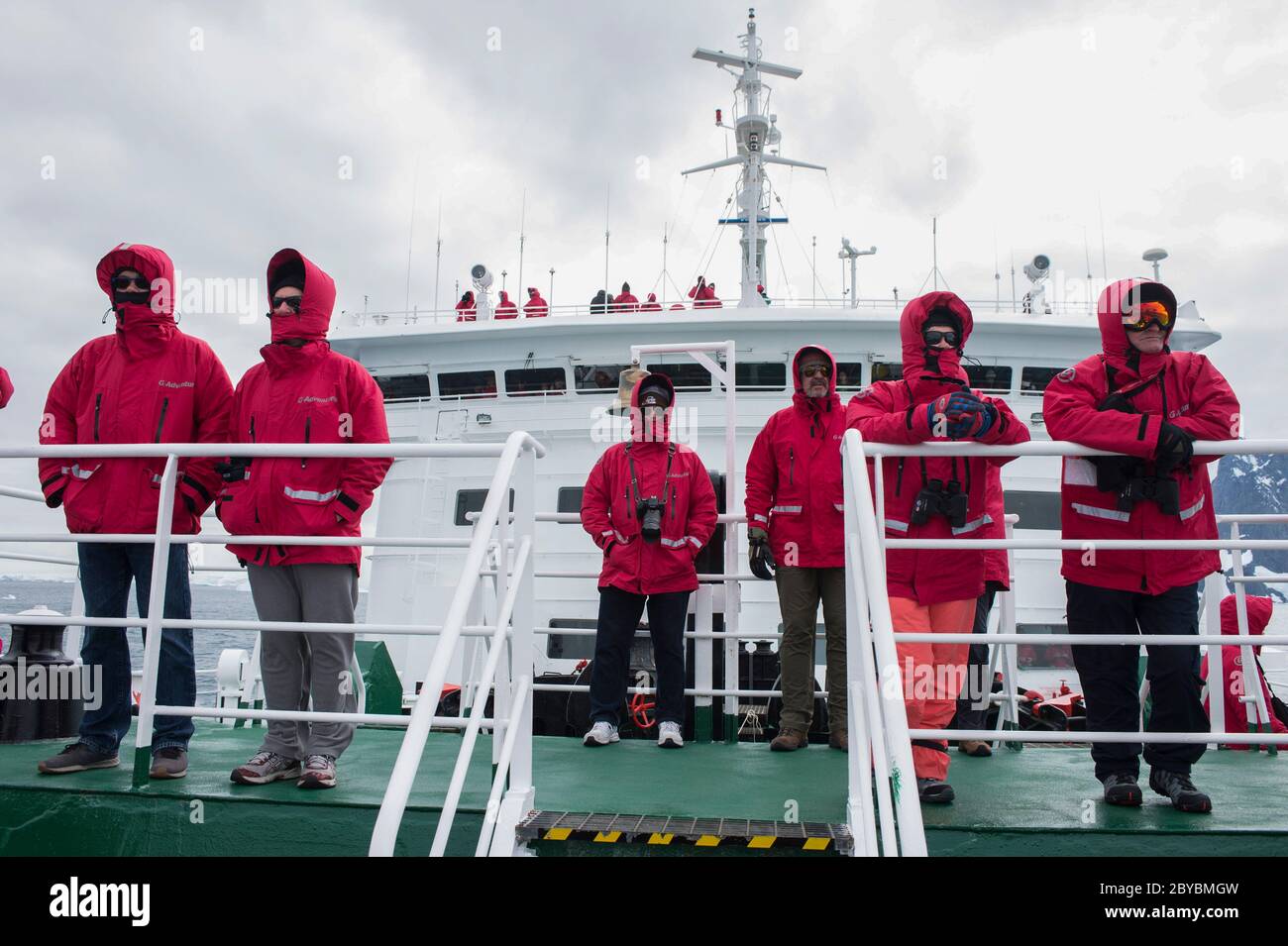 I Passener sul ponte di osservazione al G Expedtion nave passa Attraverso il canale Lemaire Antartide Foto Stock