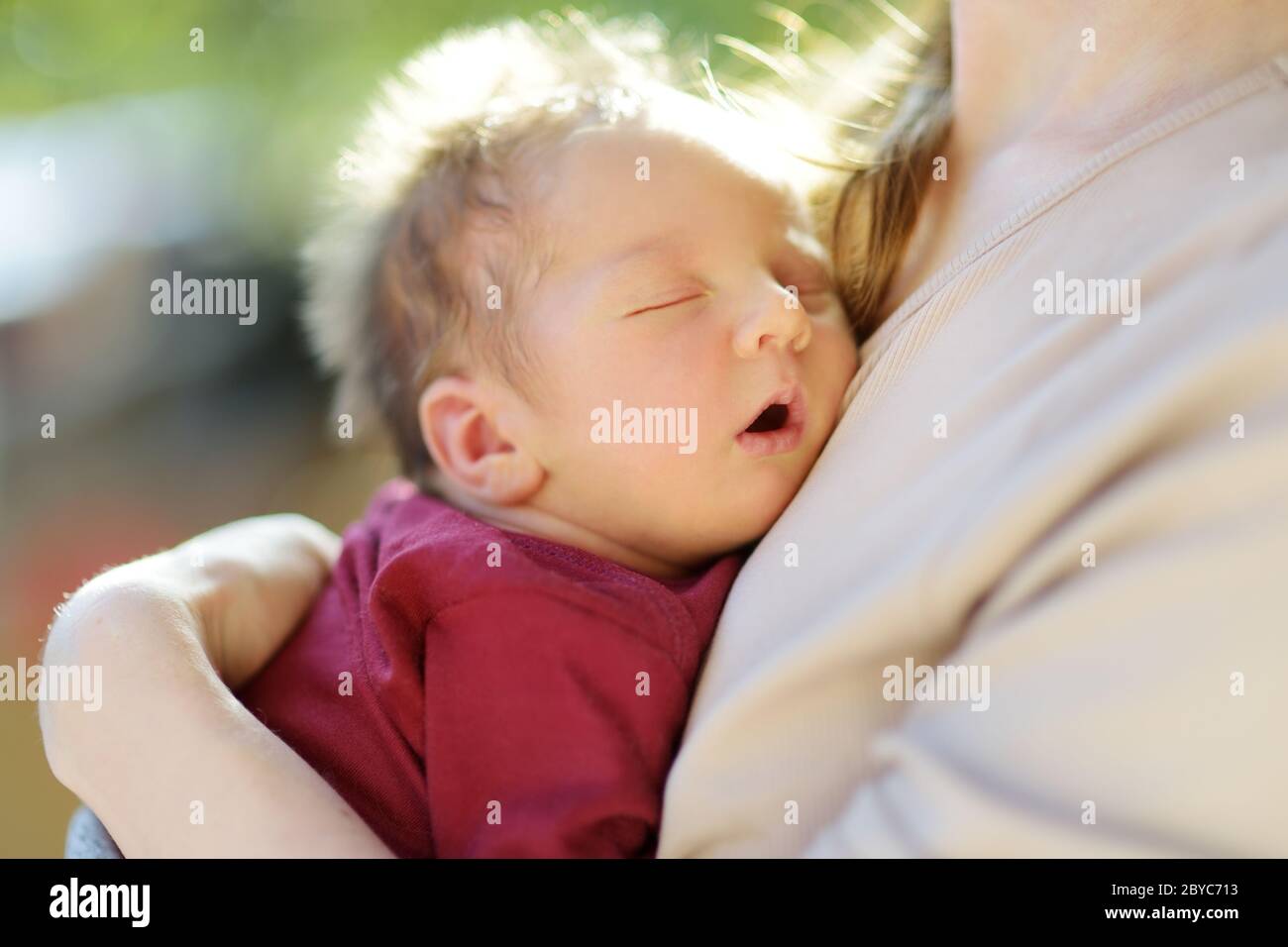 Carino bambino neonato bambino nelle braccia delle mamme. Ritratto di un piccolo bambino a casa. Adorabile figlio tenuto dalla sua mummia. Nuovo pacchetto di gioia. Foto Stock