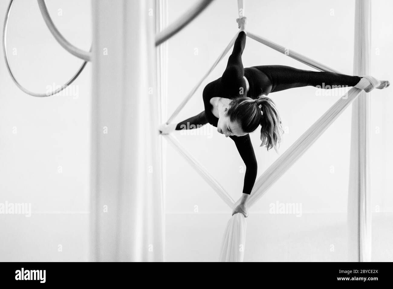 Una ballerina aerea colombiana esegue un trucco di equilibrio sulle sete aeree durante una sessione di allenamento in una palestra a Medellín, Colombia. Foto Stock