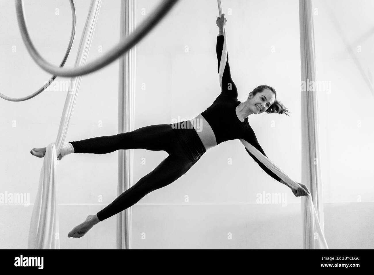 Una ballerina aerea colombiana esegue una coreografia sulle sete aeree durante una sessione di allenamento in una palestra a Medellín, Colombia. Foto Stock