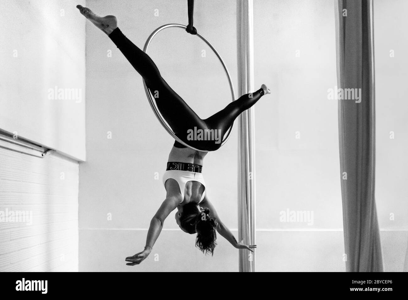 Una ballerina aerea colombiana mostra le sue abilità acrobatiche su un anello aereo durante una sessione di allenamento in una palestra a Medellín, Colombia. Foto Stock