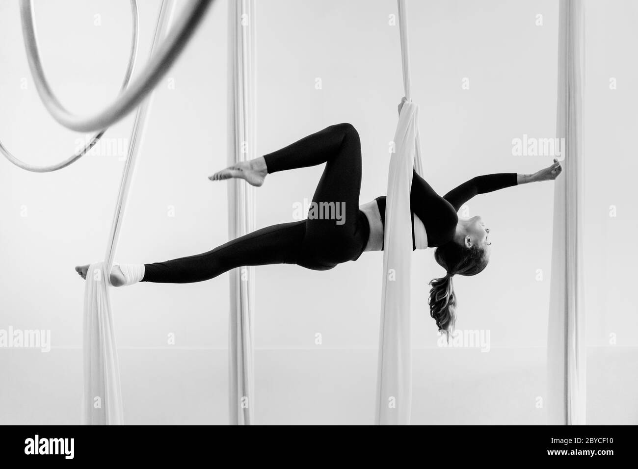 Una ballerina aerea colombiana esegue un trucco avvolgente sulle sete aeree durante una sessione di allenamento in una palestra a Medellín, Colombia. Foto Stock