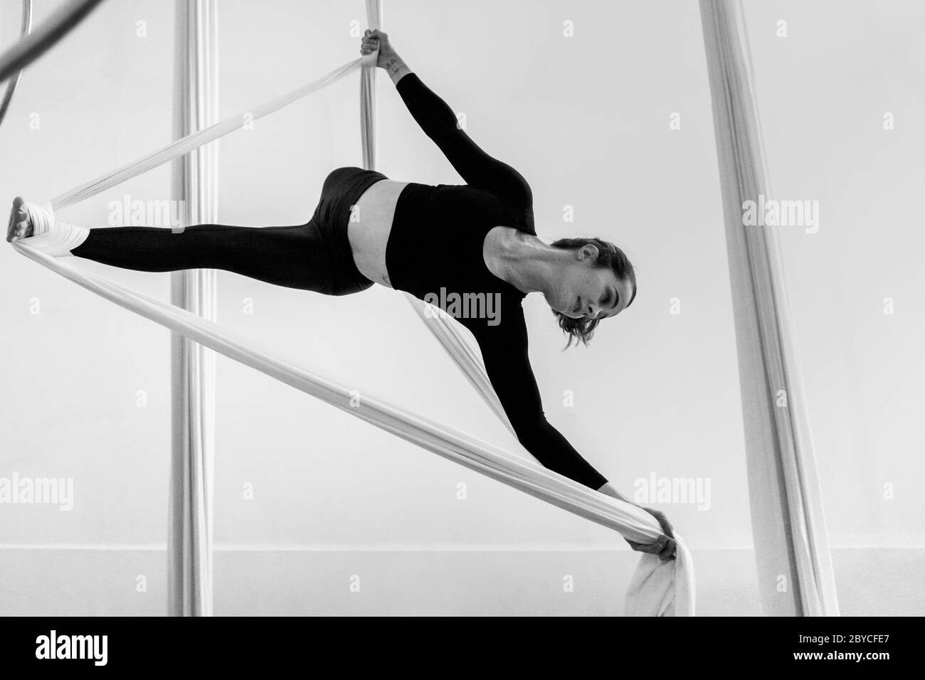 Una ballerina aerea colombiana esegue un trucco avvolgente sulle sete aeree durante una sessione di allenamento in una palestra a Medellín, Colombia. Foto Stock