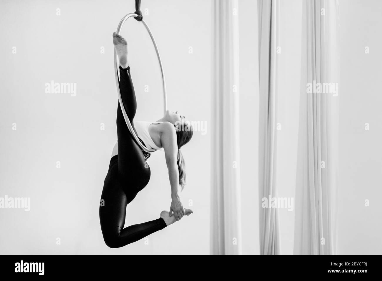 Una ballerina aerea colombiana mostra le sue abilità acrobatiche su un anello aereo durante una sessione di allenamento in una palestra a Medellín, Colombia. Foto Stock