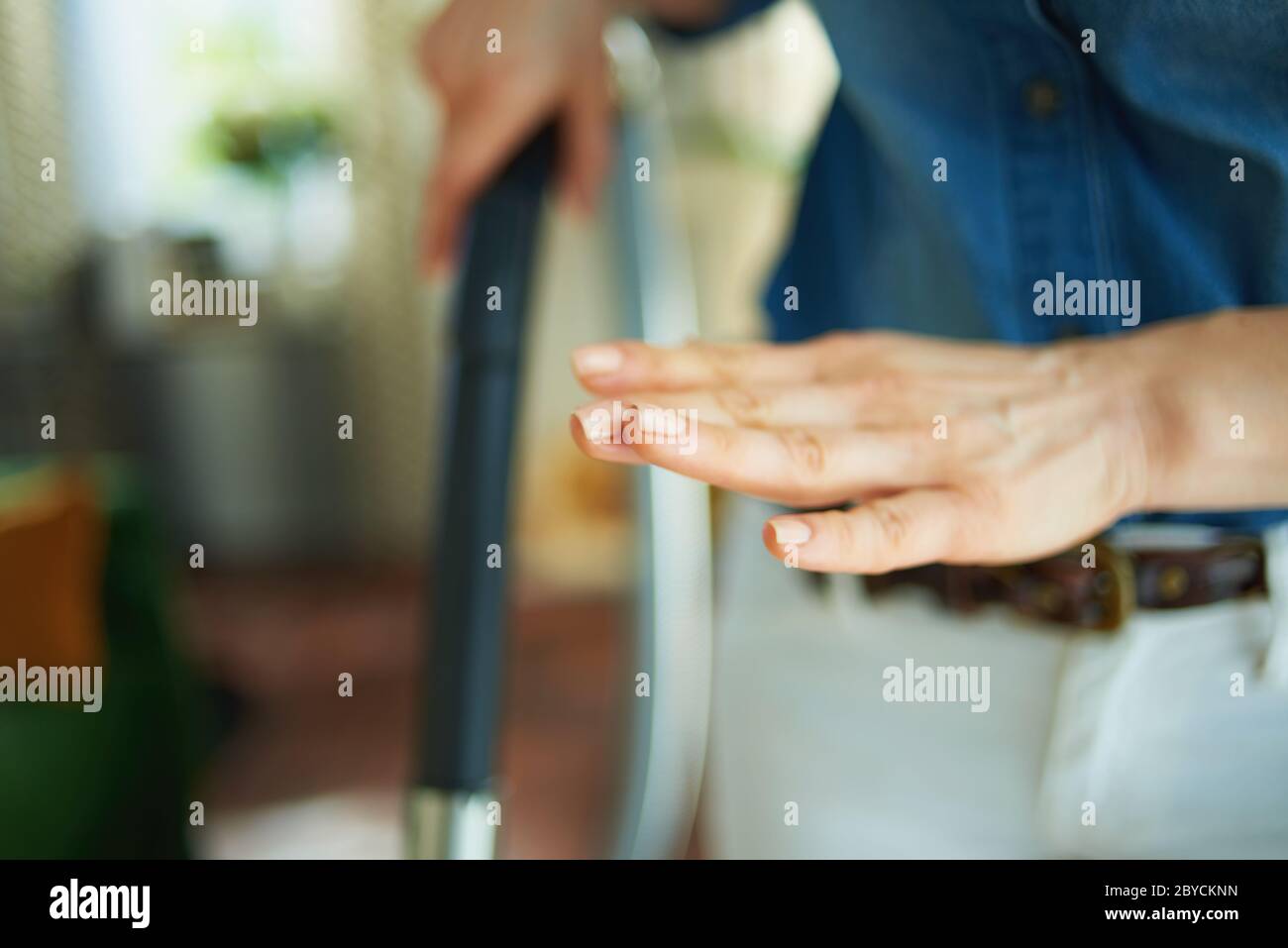 Primo piano su donna nel soggiorno in giornata di sole che controlla le unghie dopo la pulizia. Foto Stock