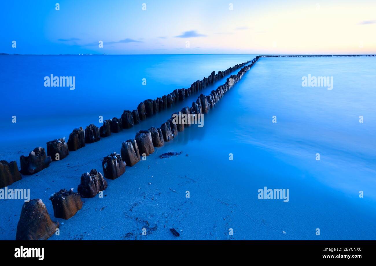 vecchia frangiflutti in mare con lunga esposizione Foto Stock