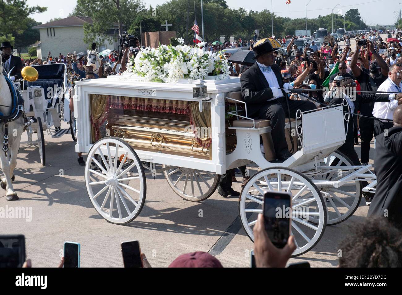 Una carrozza trainata da cavalli contenente il corpo di George Floyd si avvicina al cimitero dei Memorial Gardens di Houston, nella periferia di Houston, dove sarà sepolto accanto alla madre. La morte di Floyd, ucciso a fine maggio da un poliziotto bianco, ha scatenato proteste in tutto il mondo contro il razzismo e la brutalità della polizia. Foto Stock