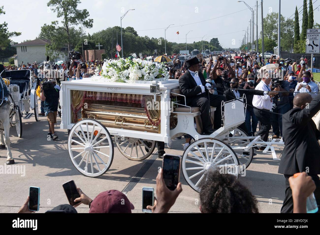 Una carrozza trainata da cavalli contenente il corpo di George Floyd si avvicina al cimitero dei Memorial Gardens di Houston, nella periferia di Houston, dove sarà sepolto accanto alla madre. La morte di Floyd, ucciso a fine maggio da un poliziotto bianco, ha scatenato proteste in tutto il mondo contro il razzismo e la brutalità della polizia. Foto Stock