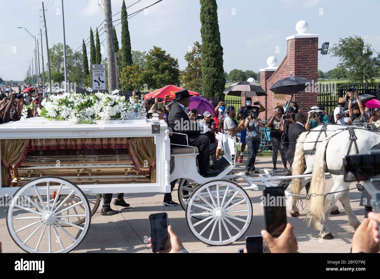 Una carrozza trainata da cavalli contenente il corpo di George Floyd si avvicina al cimitero dei Memorial Gardens di Houston, nella periferia di Houston, dove sarà sepolto accanto alla madre. La morte di Floyd, ucciso a fine maggio da un poliziotto bianco, ha scatenato proteste in tutto il mondo contro il razzismo e la brutalità della polizia. Foto Stock