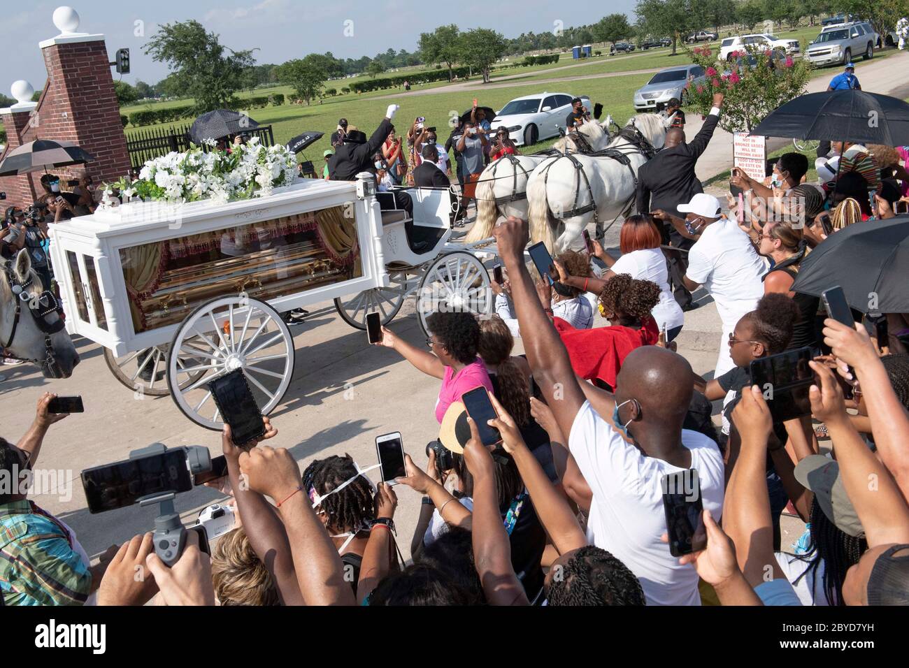 Una carrozza trainata da cavalli contenente il corpo di George Floyd si avvicina al cimitero dei Memorial Gardens di Houston, nella periferia di Houston, dove sarà sepolto accanto alla madre. La morte di Floyd, ucciso a fine maggio da un poliziotto bianco, ha scatenato proteste in tutto il mondo contro il razzismo e la brutalità della polizia. Foto Stock