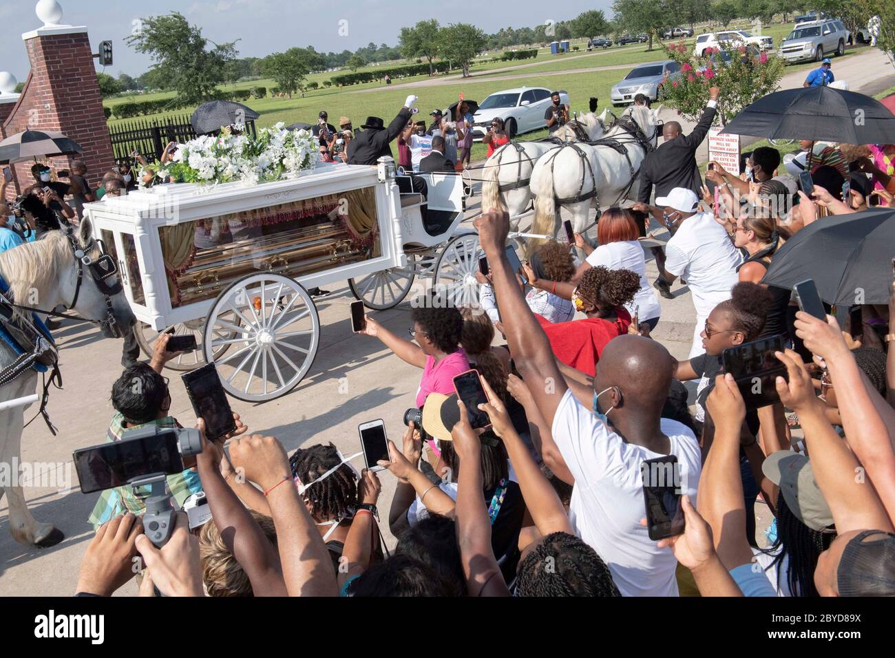 Una carrozza trainata da cavalli contenente il corpo di George Floyd si avvicina al cimitero dei Memorial Gardens di Houston, nella periferia di Houston, dove sarà sepolto accanto alla madre. La morte di Floyd, ucciso a fine maggio da un poliziotto bianco, ha scatenato proteste in tutto il mondo contro il razzismo e la brutalità della polizia. Foto Stock