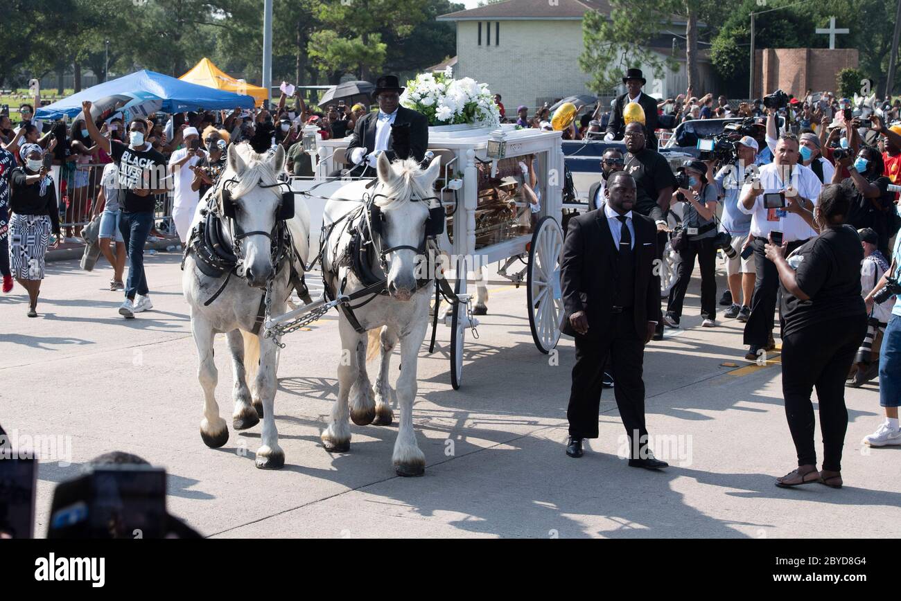 Una carrozza trainata da cavalli contenente il corpo di George Floyd si avvicina al cimitero dei Memorial Gardens di Houston, nella periferia di Houston, dove sarà sepolto accanto alla madre. La morte di Floyd, ucciso a fine maggio da un poliziotto bianco, ha scatenato proteste in tutto il mondo contro il razzismo e la brutalità della polizia. Foto Stock