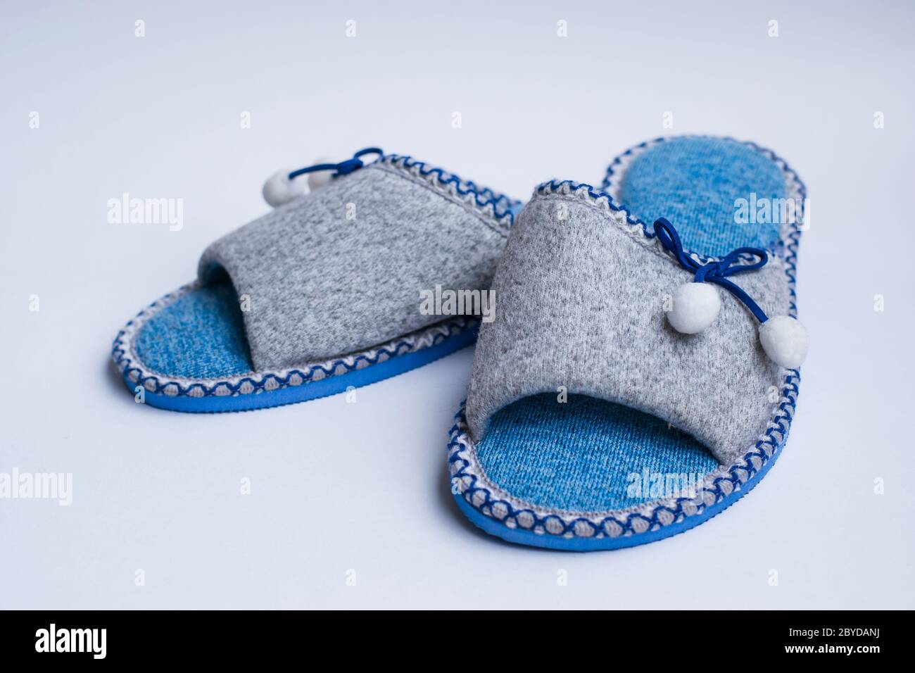 Pantofole con pomponi isolati su fondo bianco. Abbigliamento domestico per donna o bambini. Il concetto di calore e comfort domestici Foto Stock