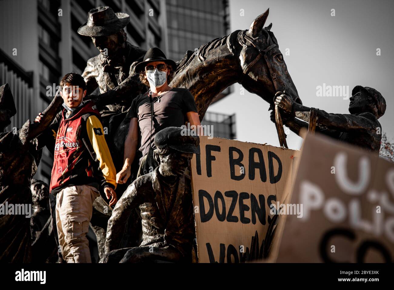 Giovani uomini salire statua a protesta BLM Foto Stock