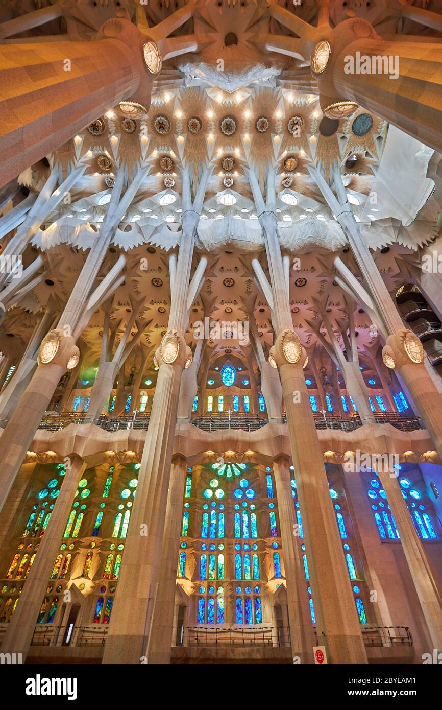 Su un lato della Sagrada Familia le vetrate si avvantaggiano del sole che tramonta, con colori caldi rossi, arance e gialli. Il redelc. Sull'altro lato Foto Stock
