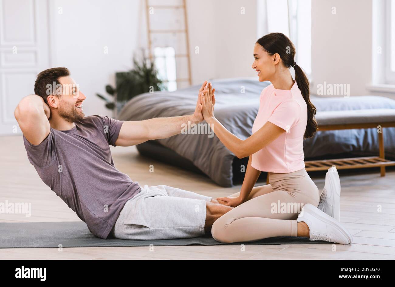 Coppia sportiva formazione insieme facendo l'ABS esercizio a casa Foto Stock