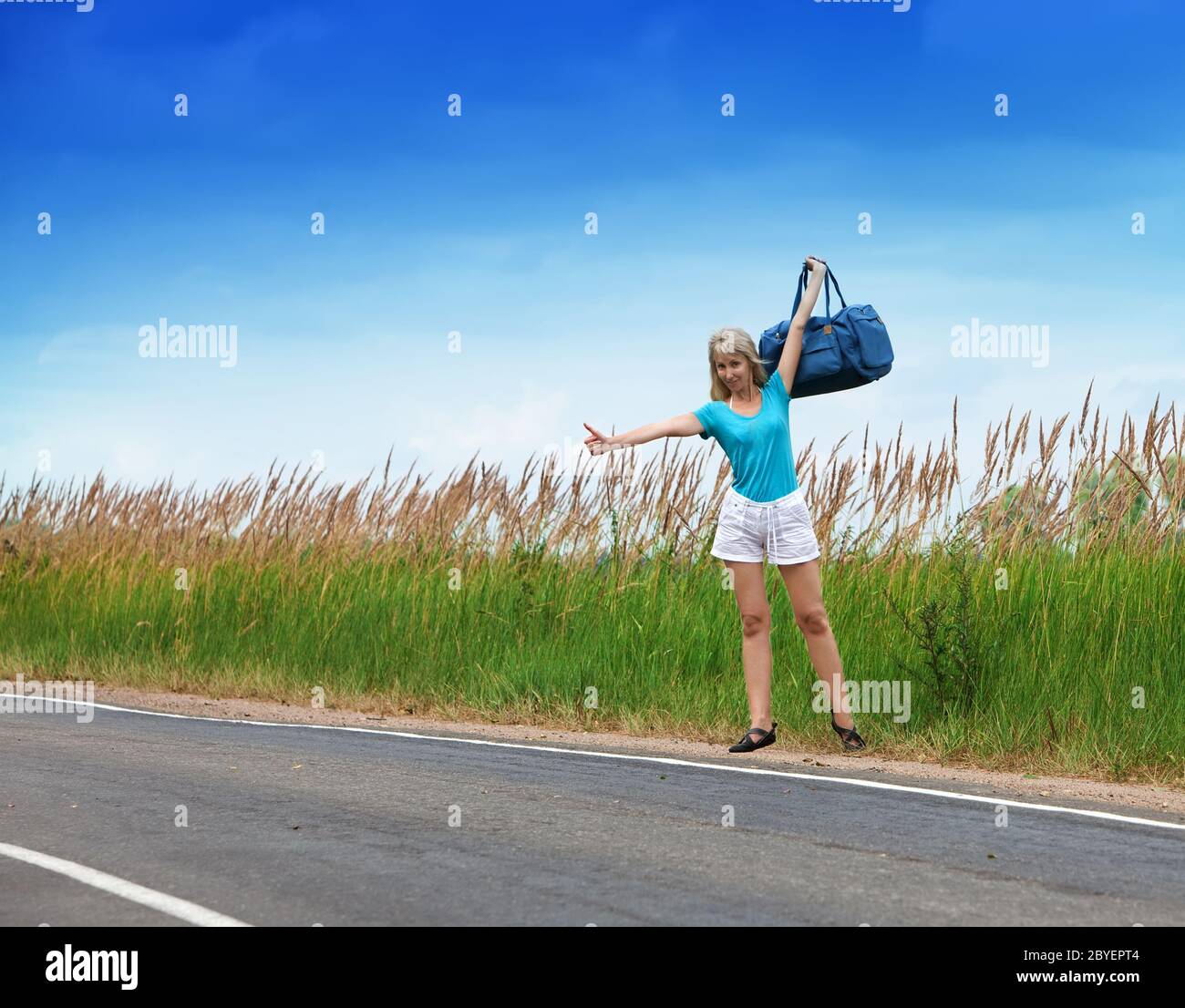 Autostop ragazza voti su strada Foto Stock