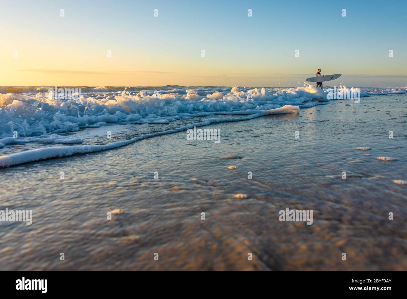 Surfista della Florida a Jacksonville Beach in una colorata mattinata all'alba. (STATI UNITI) Foto Stock