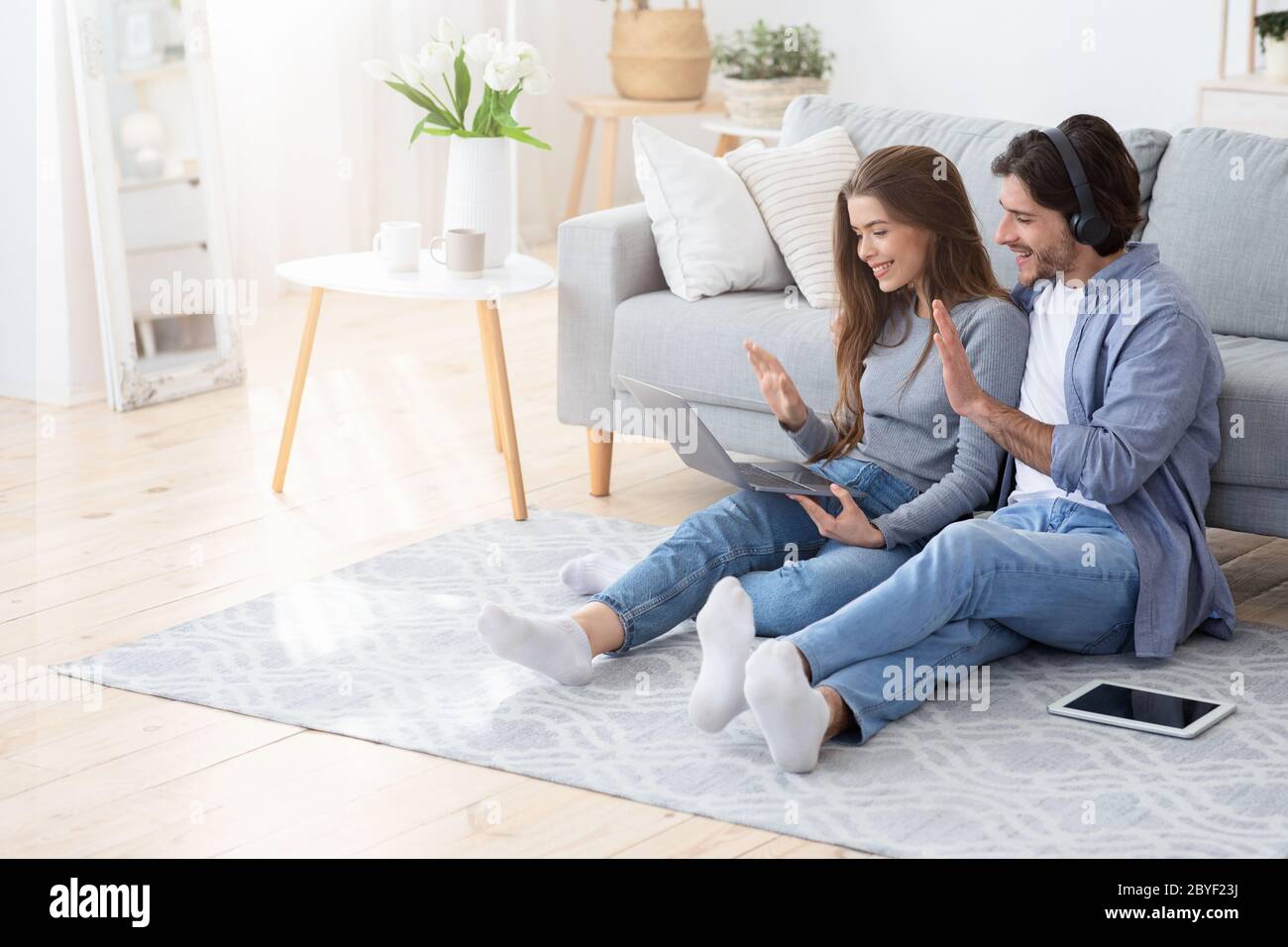 Giovane coppia amichevole che ha videoconferenza con i parenti Foto Stock