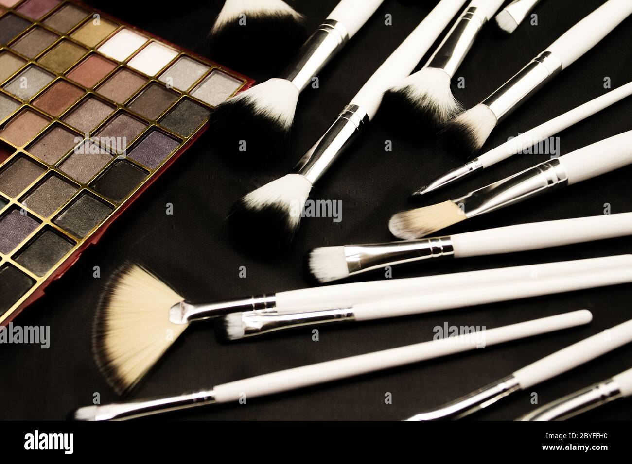 Spazzole e make up eye shadows (sfondo scuro) Foto Stock