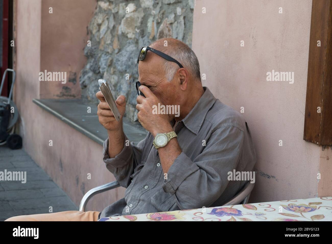 Un uomo ha bisogno di lenti d'ingrandimento per leggere. Foto Stock