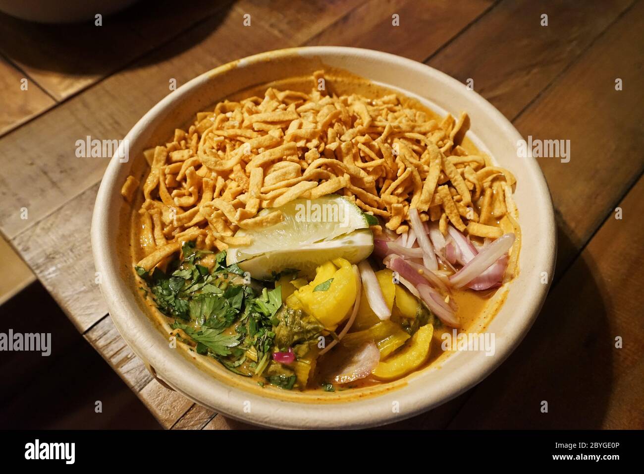 Primo piano ciotola di Khao Soi (Khao Soy), zuppa di noodle al curry della Thailandia del Nord Foto Stock