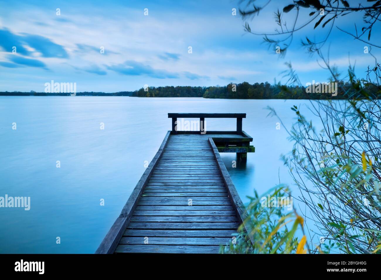 molo in legno sul grande lago con lunga esposizione Foto Stock