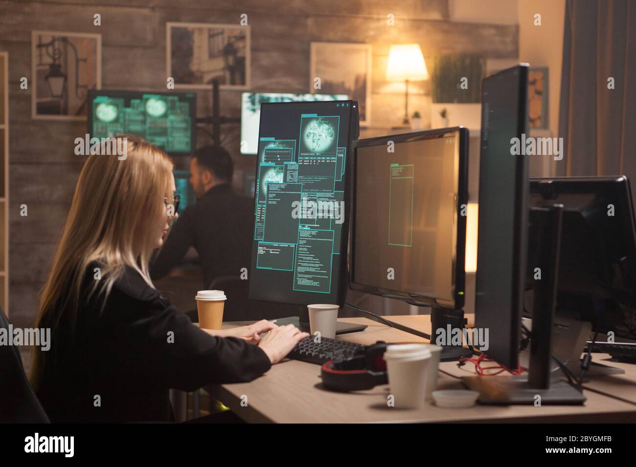 Hacker femmina non conformista che fa un malware dannoso con il suo team. Foto Stock