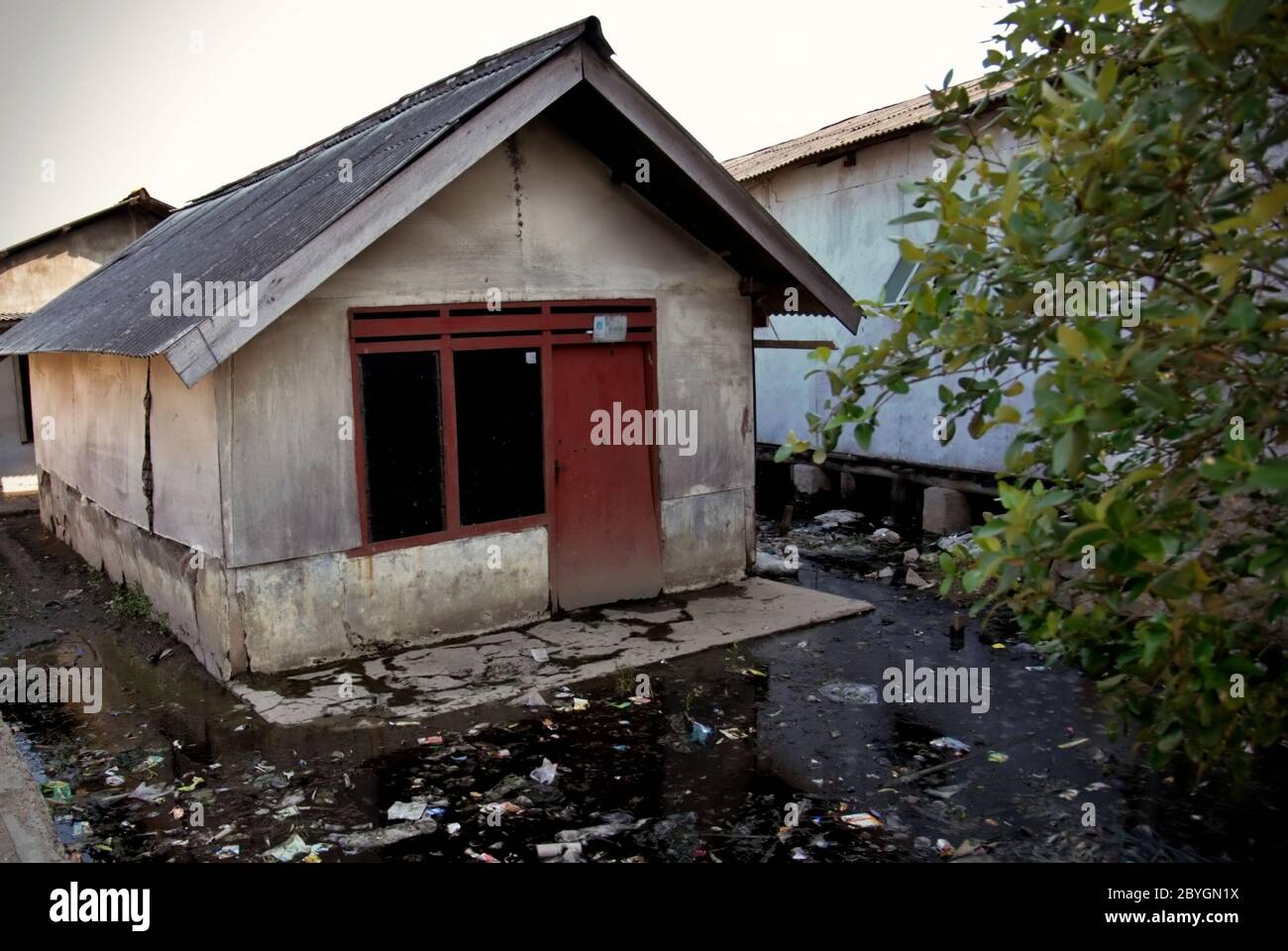 Una casa residenziale che soffre di affondamento della terra e inondazioni costiere nel villaggio di Marunda, Jakarta Nord, Giacarta, Indonesia. Foto Stock