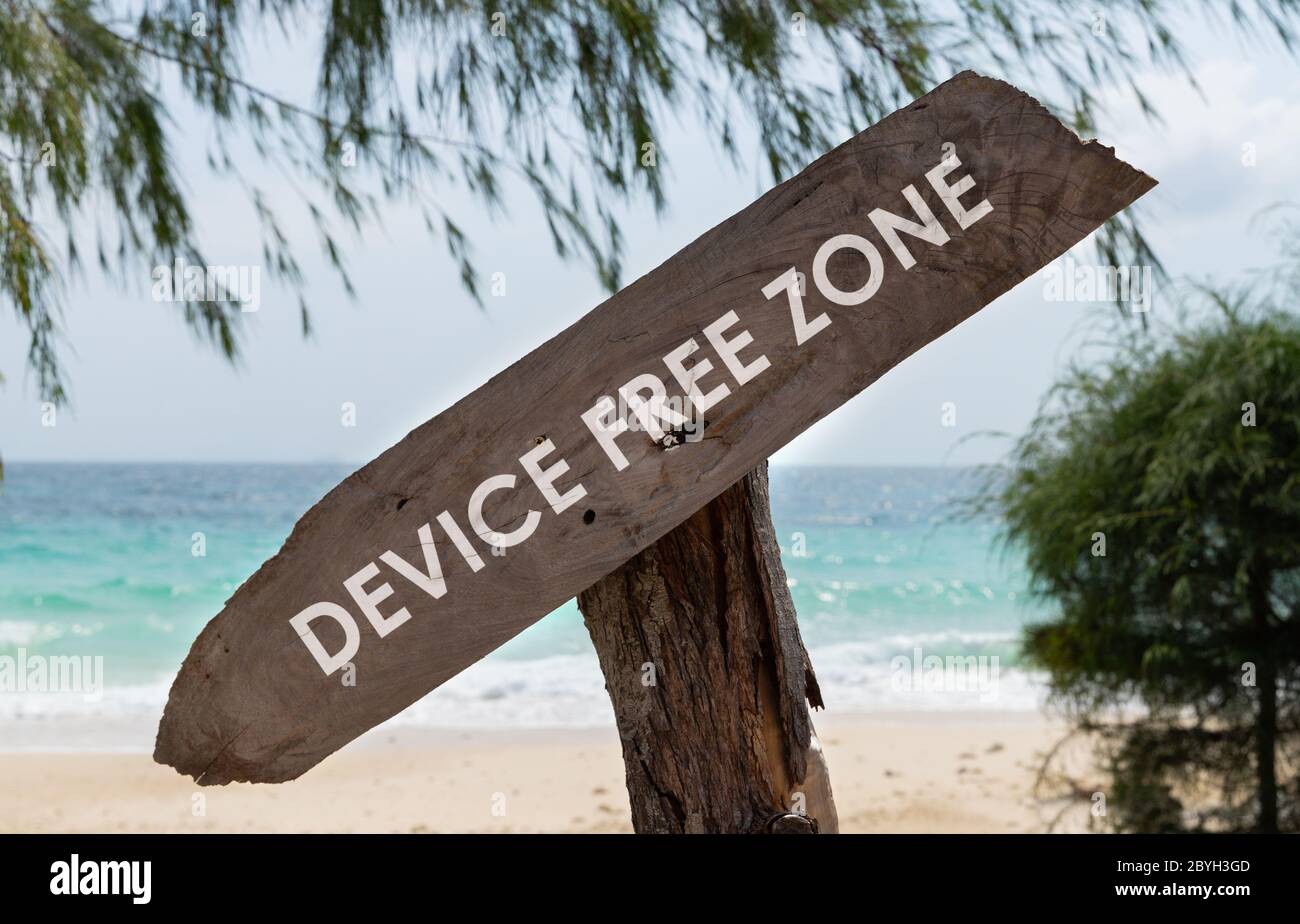 Vecchio cartello di legno con dispositivo di testo zona libera sulla spiaggia tropicale Foto Stock