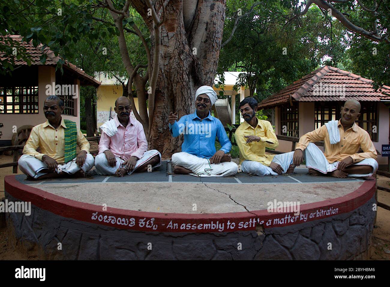 Icone di cinque saggi seduti sulla piattaforma di pietra del villaggio sotto l'albero al Museo d'Arte Folcloristica Janapada Loka vicino a Ramanagara, Karnataka, India, Asia Foto Stock