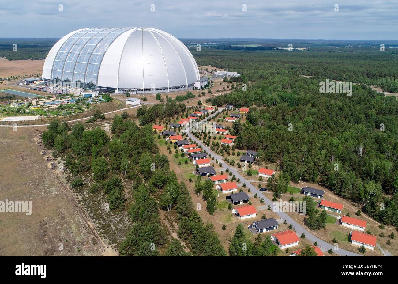 10 giugno 2020, Brandeburgo, Krausnick: Case vacanze si trovano di fronte alla sala del parco a tema delle isole tropicali (foto aerea scattata con un drone). Secondo le proprie dichiarazioni, il più grande mondo di vacanze tropicali d'Europa riprenderà le attività degli ospiti dal 15.06.2020. Il parco divertimenti era stato chiuso per tre mesi a causa del virus corona. Attualmente, nelle isole tropicali si stanno preparando in modo definitivo per la riapertura. Il concetto è dimezzare la capacità in modo che vi sia spazio sufficiente per ogni ospite per mantenere le normative sulla distanza. Fino a ulteriore avviso, i biglietti giornalieri sono disponibili solo Foto Stock