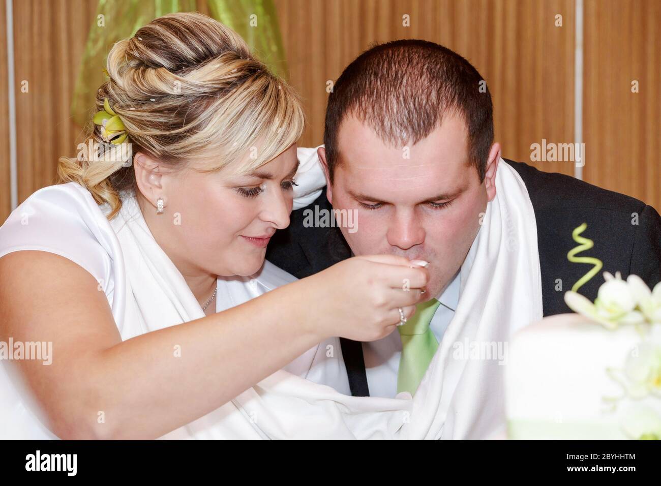 sposa che nutra il suo sposo con un cucchiaio per il pranzo di nozze Foto Stock